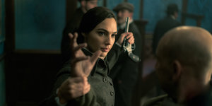 Gal Gadot als Wonder Woman nimmt in einer Szene des Films einem Mann eine Pistole ab