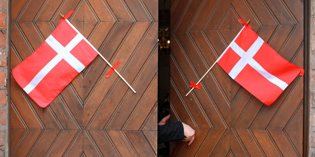 An eine Kirchentür somd zwei dänische Fahnen angebracht