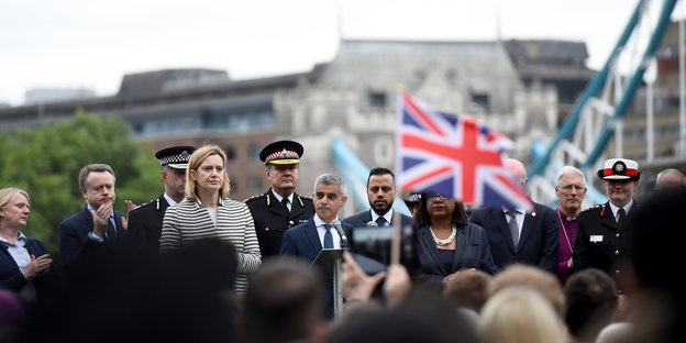 Auf einer Bühne steht Londons Bürgermeister und spricht. Vor ihm stehen viele Menschen, eine britische Flagge ist deutlich zu sehen.