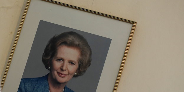 Ein gerahmtes BIld von Margaret Thatcher hängt schief an einer Wand