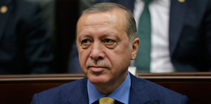 Erdogan sitzt mit deprimiertem Gesichtsausdruck da und guckt ins Leere