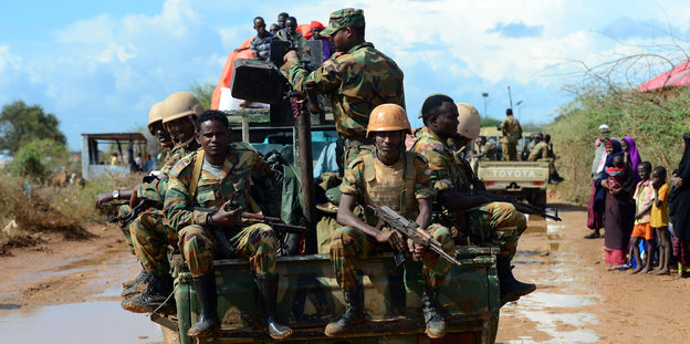 Soldaten der Afrikanischen Union sitzen in Somalia am Flüchtlingslager Hilac auf einem Auto.