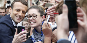 Der französische Präsident Emmanuel Macron lässt sich von Passanten fotografieren
