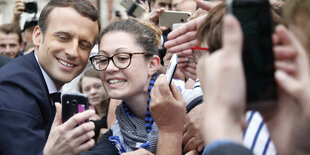 Der französische Präsident Emmanuel Macron lässt sich von Passanten fotografieren