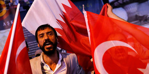 Türkische DemonstrantInnen und die Flagge von Katar