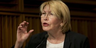 Luisa Ortega Díazguckt streng durch ihre Brille und hebt die rechte Hand gestikulierend beim Sprechen