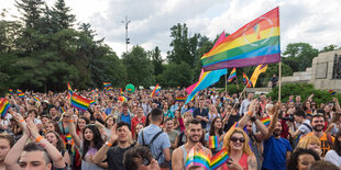 Menschen im Park mit Regenbogenfahnen