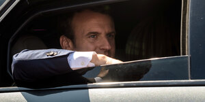 Macron auf dem Rücksitz eines Autos