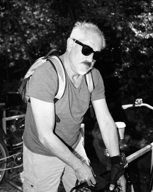 ein Mann mit Sonnenbrille schließt ein Fahrrad ab ein Mann mit Sonnenbrille schließt ein Fahrrad ab