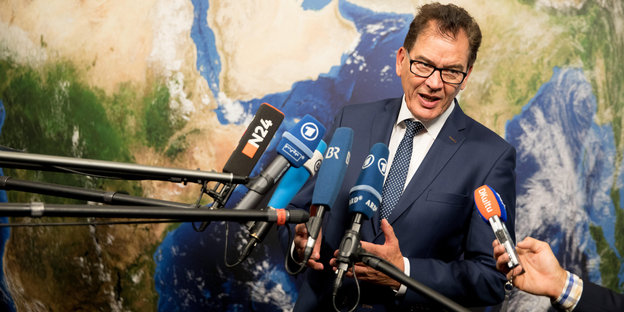 Entwicklungsminister Gerd Müller steht vor zahlreichen Mikrofonen