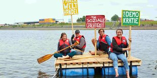 Menschen mit Schildern auf Floß