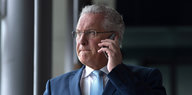 Bayern Innenminister Herrmann telefoniert und kneift die Lippen zusammen