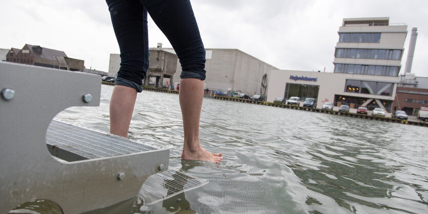 Eine Frau tritt auf Steg im Wasser in Münster.