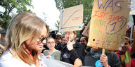 Gina Lisa Lohfink steht neben ihren Unterstützern, die Schilder in die Höhe halten