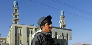 Vor einer Moschee steht ein Polizist