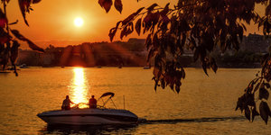 Bootsfahrer blicken auf einen Sonnenuntergang