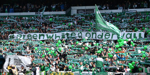 Viele Fußballfans mit Schals, Fahnen und Plakaten stehen in der Bremer Ostkurve