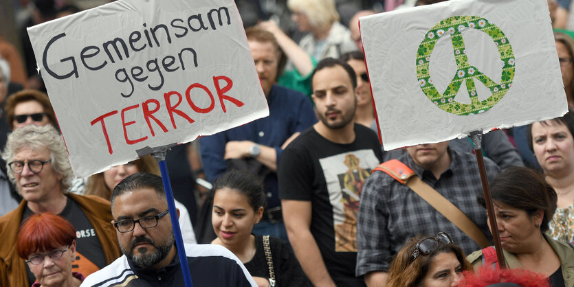 Menschen laufen auf einer Straße und halten Schilder hoch