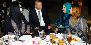Erdogan mit drei Frauen an einem gedeckten Esstisch