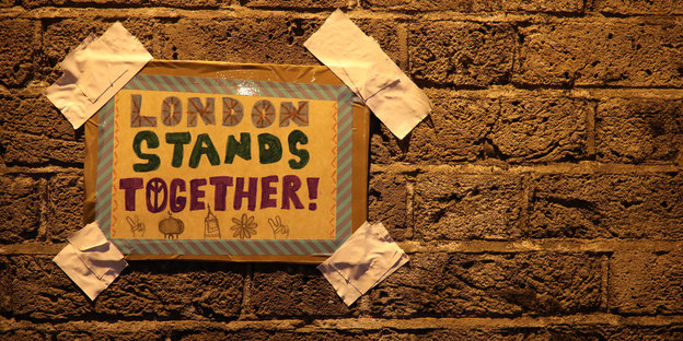 Ein Plakat mit der der Aufschrift "London stands together" an einer Mauer