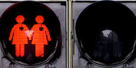 Eine rote Ampel zeigt zwei sich an der Hand haltende Frauen