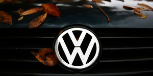 VW-Logo an einer mit etwas Herbstlaub bedeckten Motorhaube