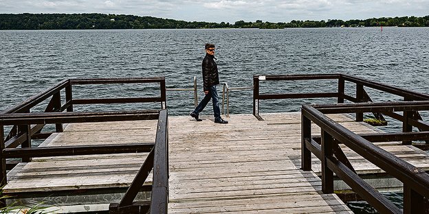 Dieter Olbricht steht auf einem Steg an einem See