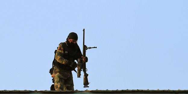 ein Soldat mit Gewehr vor blauem Himmel