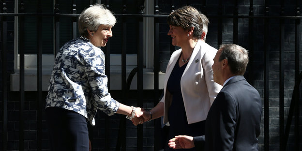 Theresa May schüttelt die Hände ihrer künftigen Koalitionspartnerin Arlene Foster