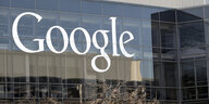 Google steht in weißer Schrift auf einer spiegelnden Fensterscheibe