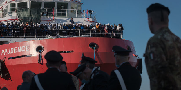 Flüchtlinge auf einem Schiff, Polizisten im Hafen