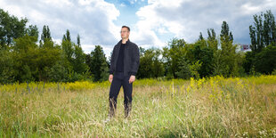 Ein Mann auf einer Wiese, unter blauem Himmel