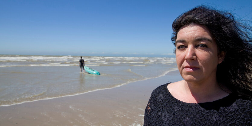 Eine Frau steht am Strand