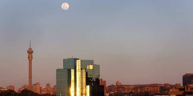 Eine Stadtsilhouette mit darüberstehendem Mond