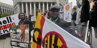 Menschen halten Transparente gegen Shell in den Händen