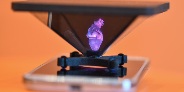 Smartphone mit 3-D-Aufsatz zeigt ein Herz.