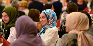 Muslima mit Kopftüchern, zwei von hinten, zwei lächelnd von vorn