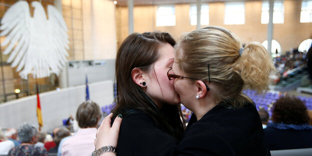 Zwei Frauen küssen sich im Zuschauerbereich des Bundestages