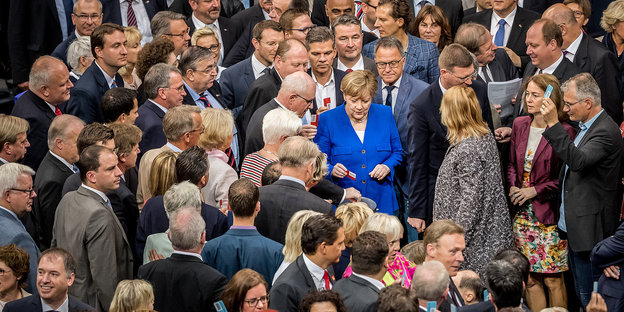 Bundeskanzlerin Angela Merkel wird im Plenum ihre rote "NEIN" Stimmkarte ein.