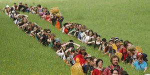 Eine Menschenkette in einem grünen Feld