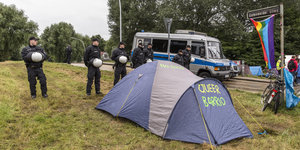 Polizisten haben ein Zelt umstellt