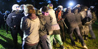 Abends: Demonstrantenkette hält gegen anstürmende Polizisten in Kampfmontur