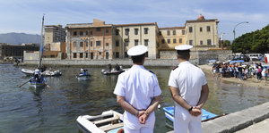Zwei italienische Küstenwächter schauen auf Boote, die im Meer schwimmen