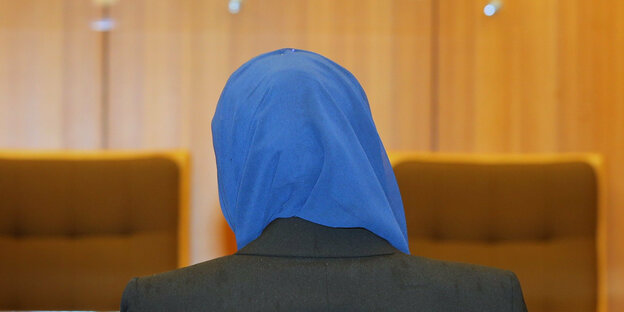 Frau mit Kopftuch in einem Gerichtssaal
