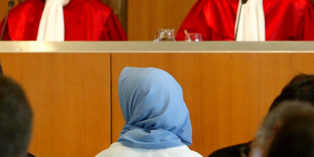 Frau mit Kopftuch vor der Richterbank