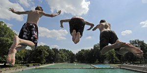 Drei Jungen springen in ein Schwimmbecken