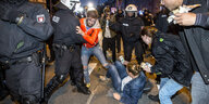 Demonstranten am Boden, darum herum Polizei