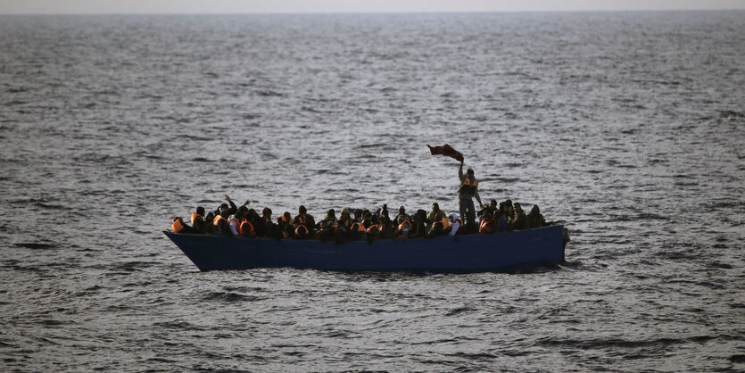 Ein kleines Boot voll mit Menschen auf dem Meer