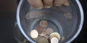 In einem durchsichtigen Plastikbecher liegt Kleingeld