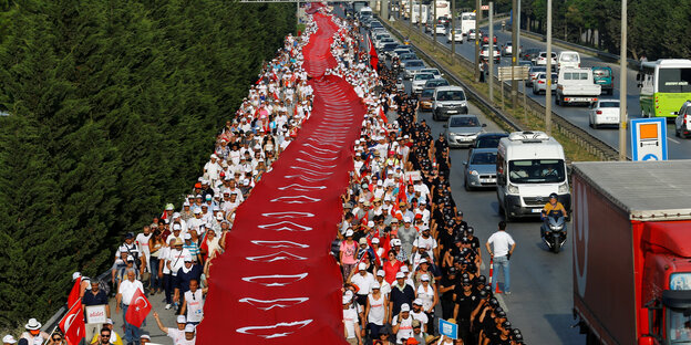 Eine große Demonstration, mittendrin eine riesige türkische Flagge